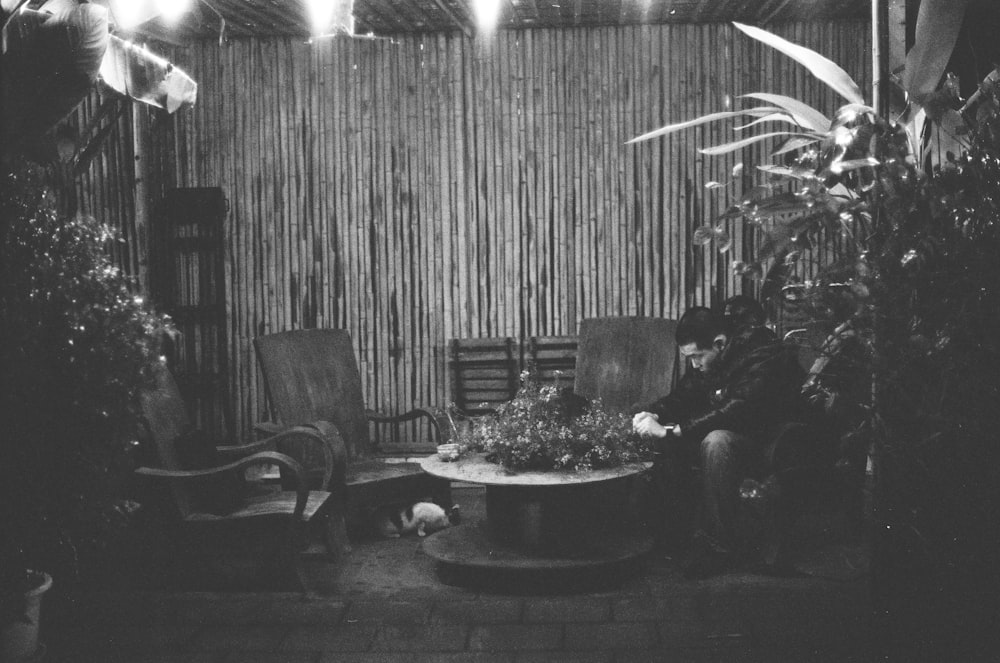 a black and white photo of a man sitting in a chair