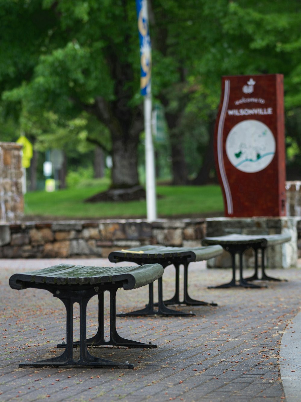 a couple of benches sitting on top of a brick walkway