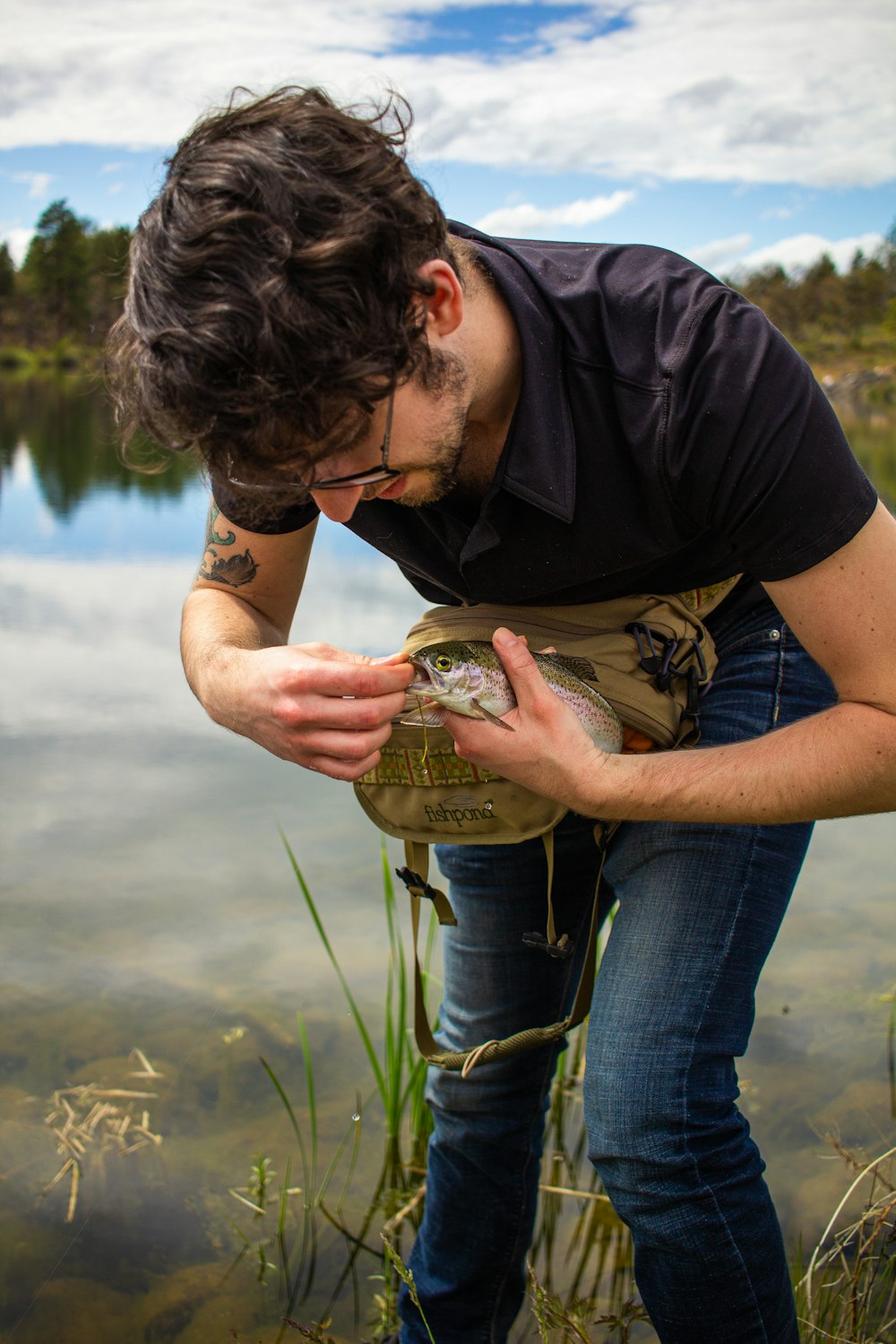 Un uomo che tiene un pesce nella mano destra