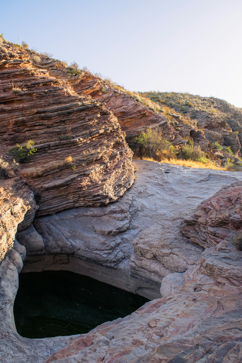 a small pool of water in the middle of a canyon