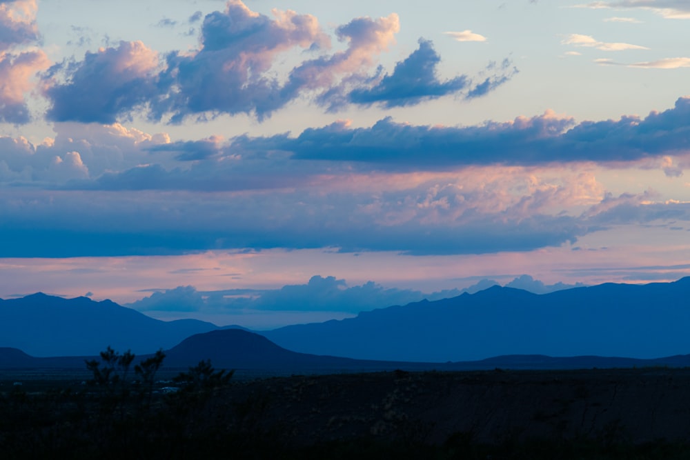 a view of a mountain range with clouds in the sky