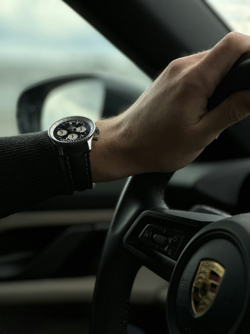 a person holding the steering wheel of a car