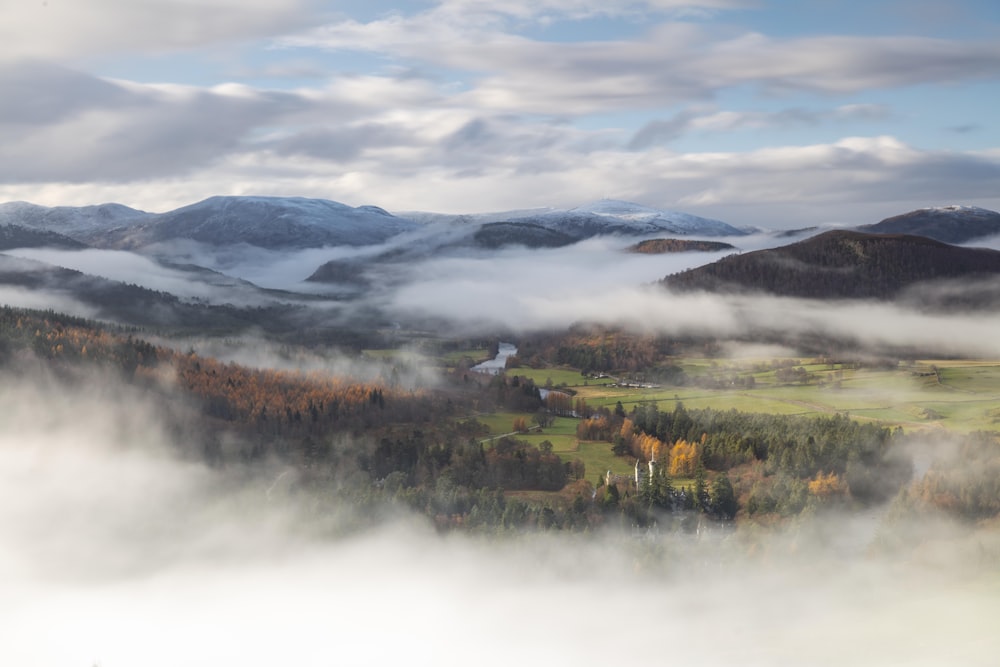 a scenic view of a valley with mountains in the background