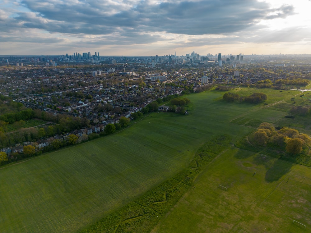 an aerial view of a city and a green field