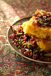 a plate of food with cranberries and pistachio