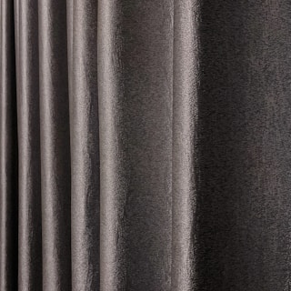 A close-up view of dark, textured drapery fabric with waves and folds creating a sense of movement. The material appears slightly shiny, indicating a smooth finish.