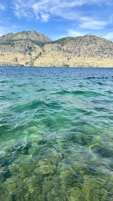 Close-up of crystal-clear water with gentle ripples reflecting a blue sky