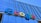The image displays a large, colorful sign with the word 'Google' mounted on the exterior of a modern glass building. The letters are in bold, distinctly colored fonts against a backdrop of reflective windows and metallic structures.