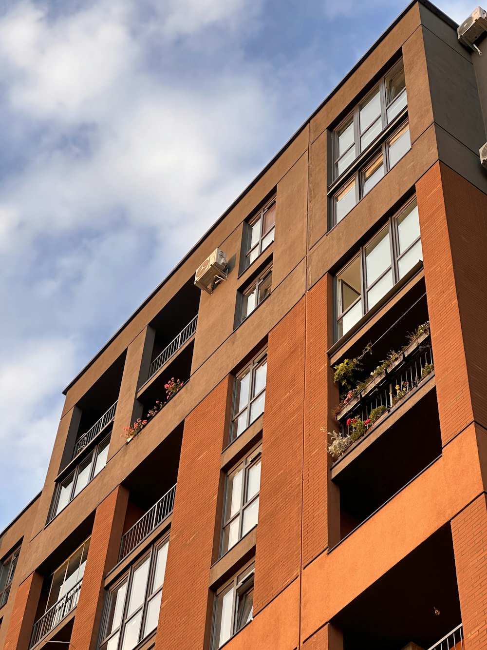 um edifício alto com varandas e plantas nas varandas