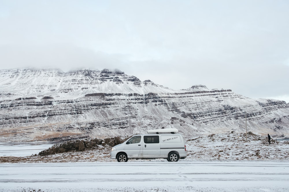 a white van driving down a snow covered road