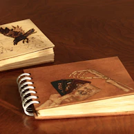 Close-up of hands exchanging sketchbooks filled with creative and bold design concepts.