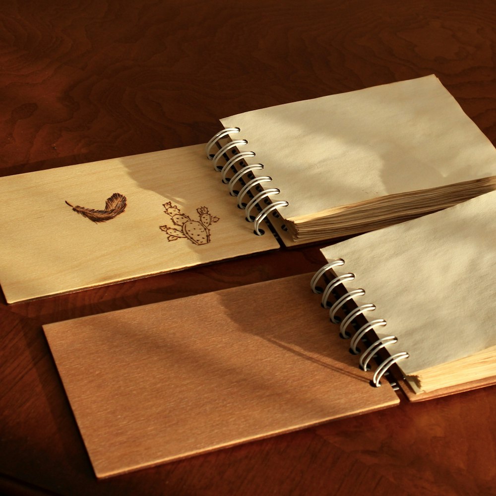 two notebooks sitting on top of a wooden table