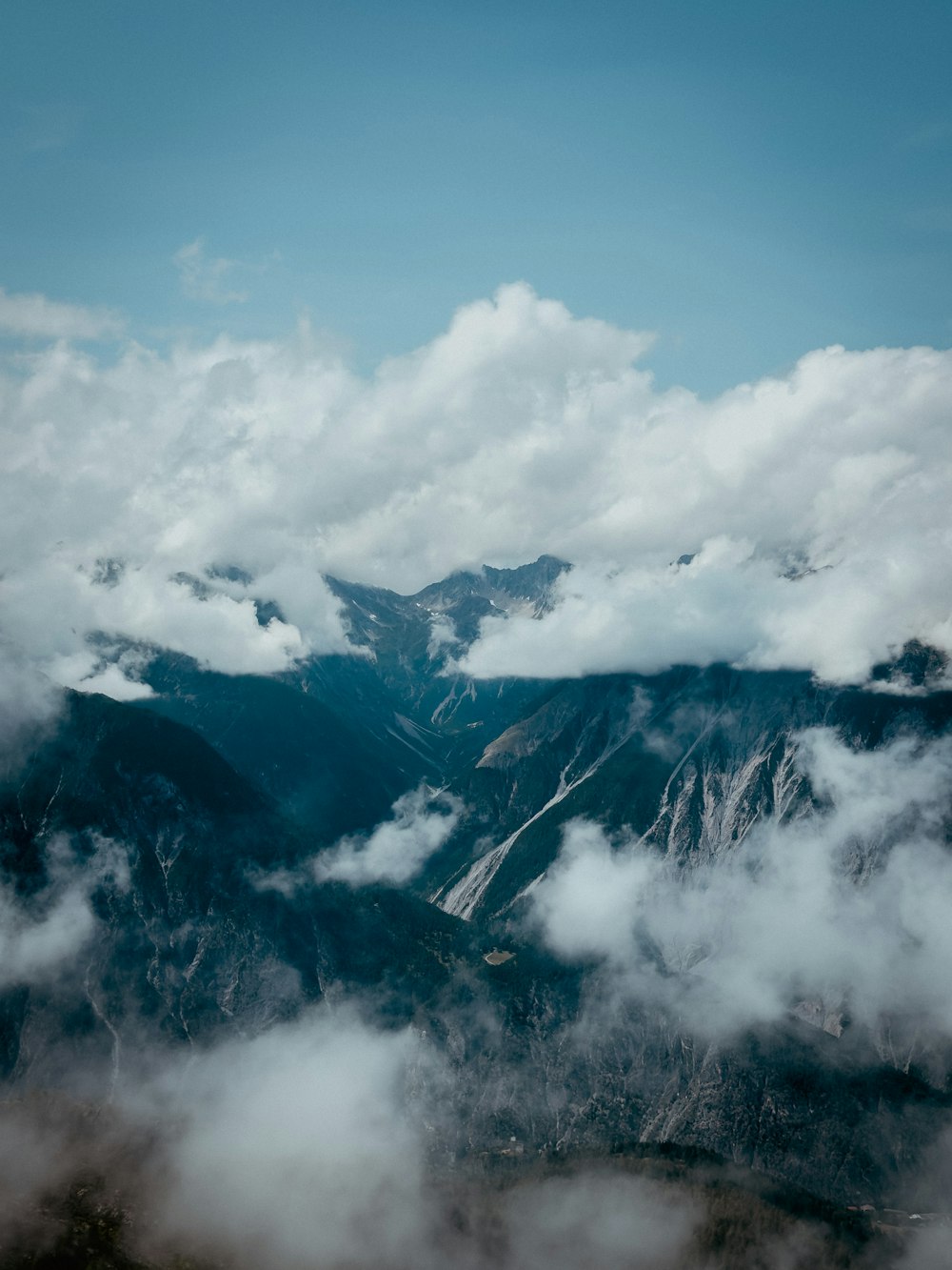 a view of a mountain range covered in clouds