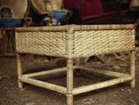 An elegant rattan coffee table styled with tropical decor on a sandy beige rug.