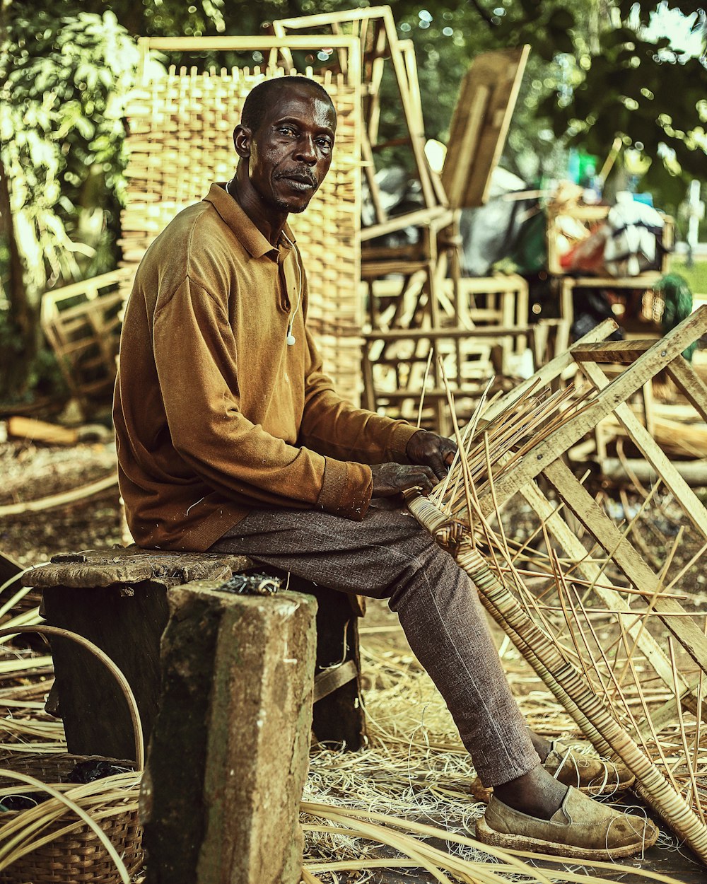a man sitting on a wooden bench holding a bamboo basket
