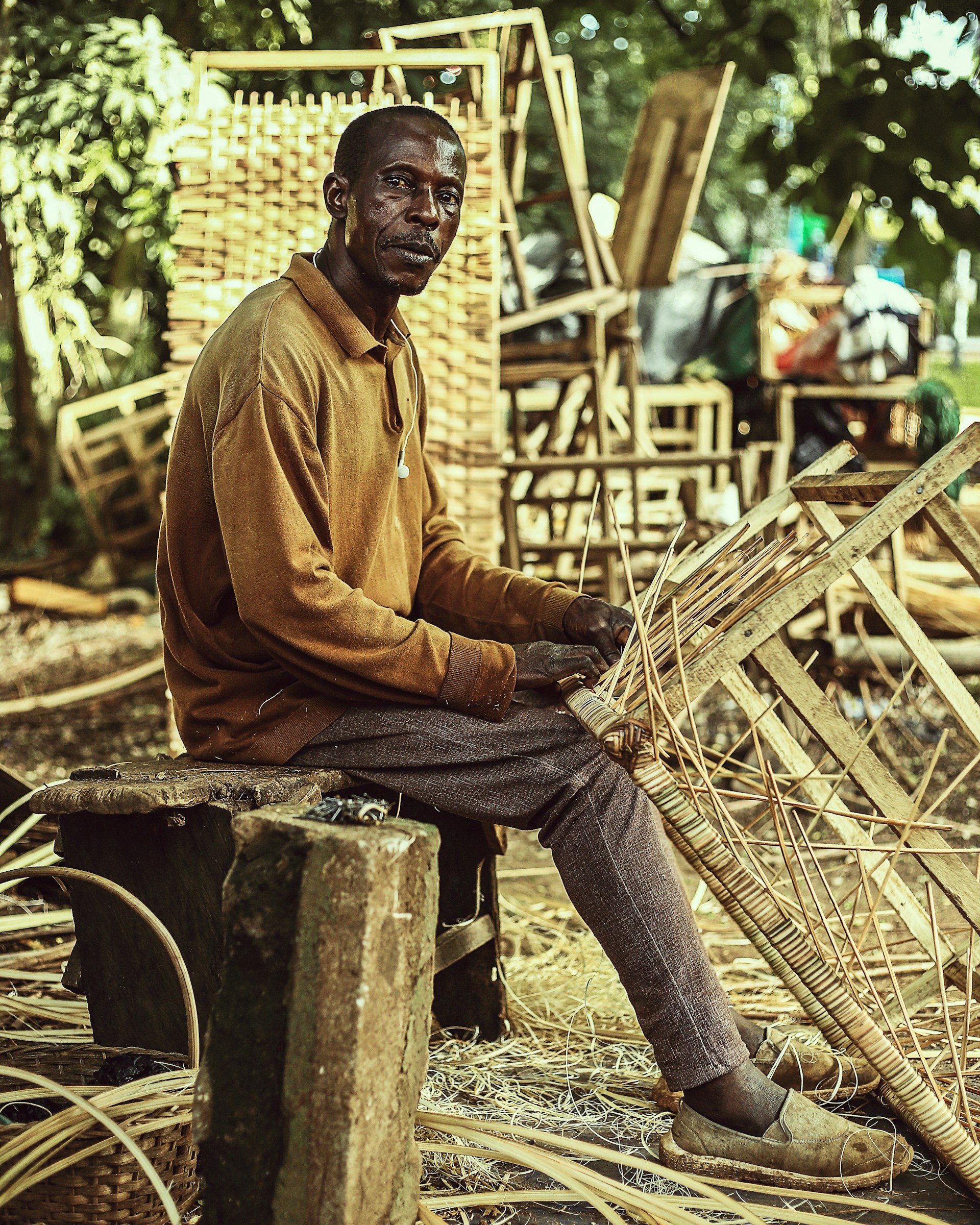 a man sitting on a wooden bench holding a bamboo basket