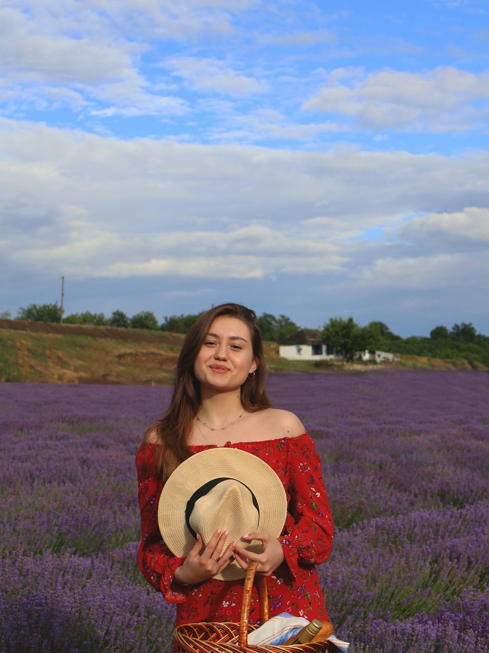 a woman standing in a field with a hat