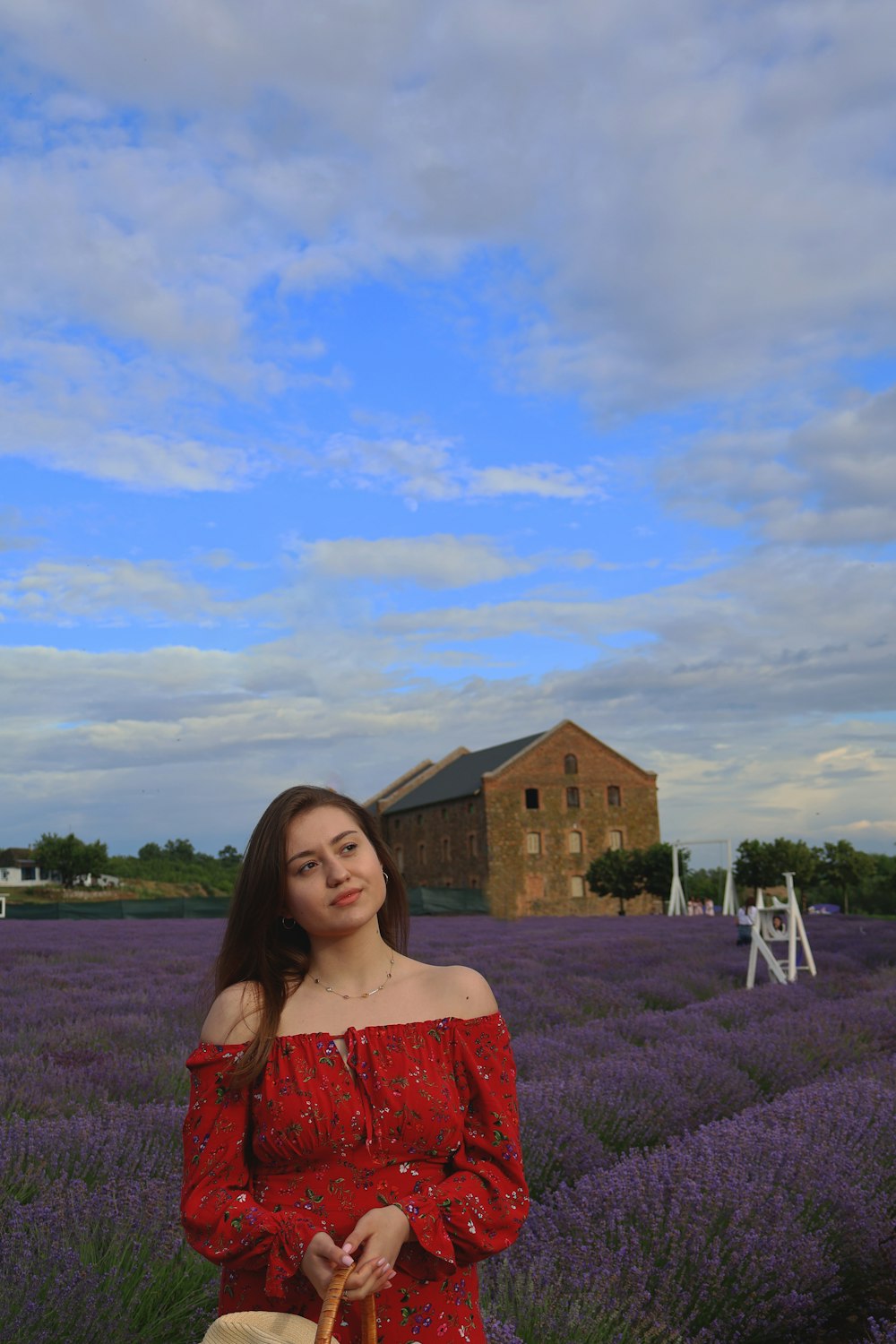 a woman in a red dress standing in a lavender field