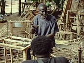 An elderly man receiving gentle assistance during a health workshop at a nursing home.