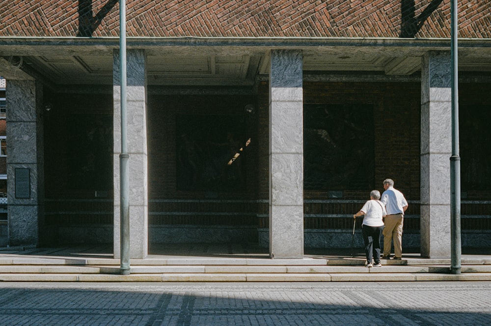 a man and a woman walking down a sidewalk