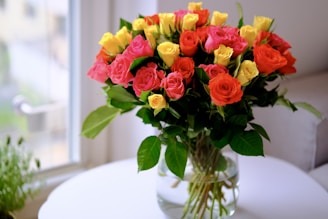 a vase filled with lots of different colored roses