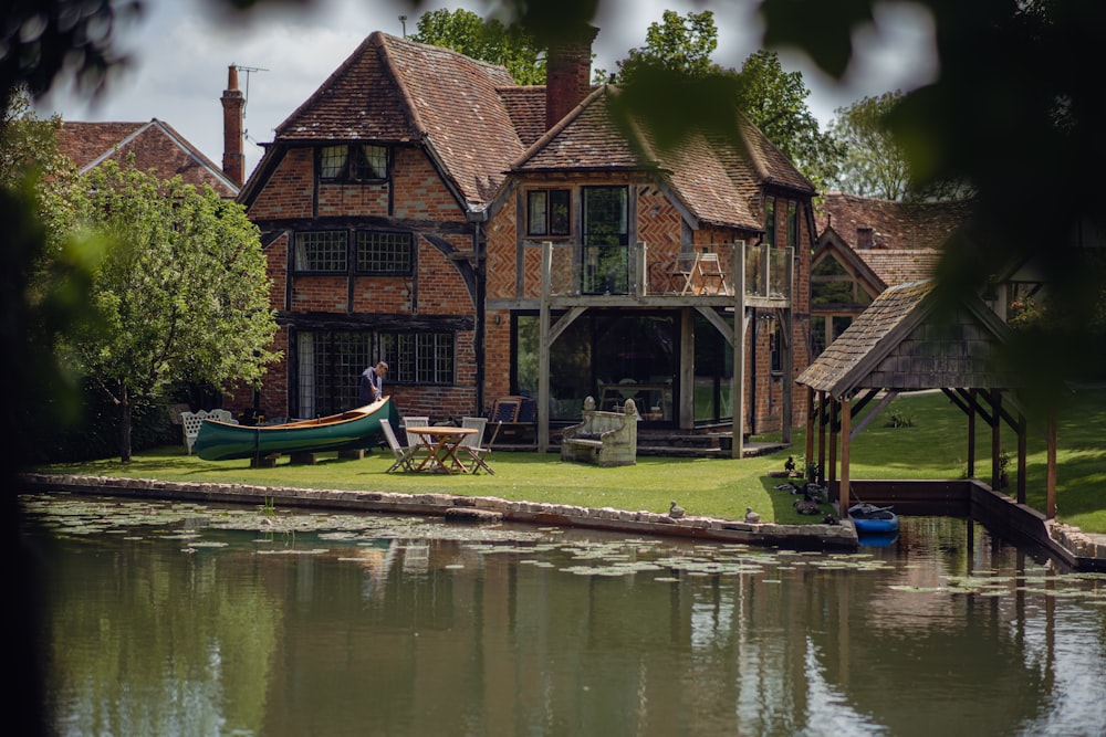 uma casa com um barco na água à sua frente