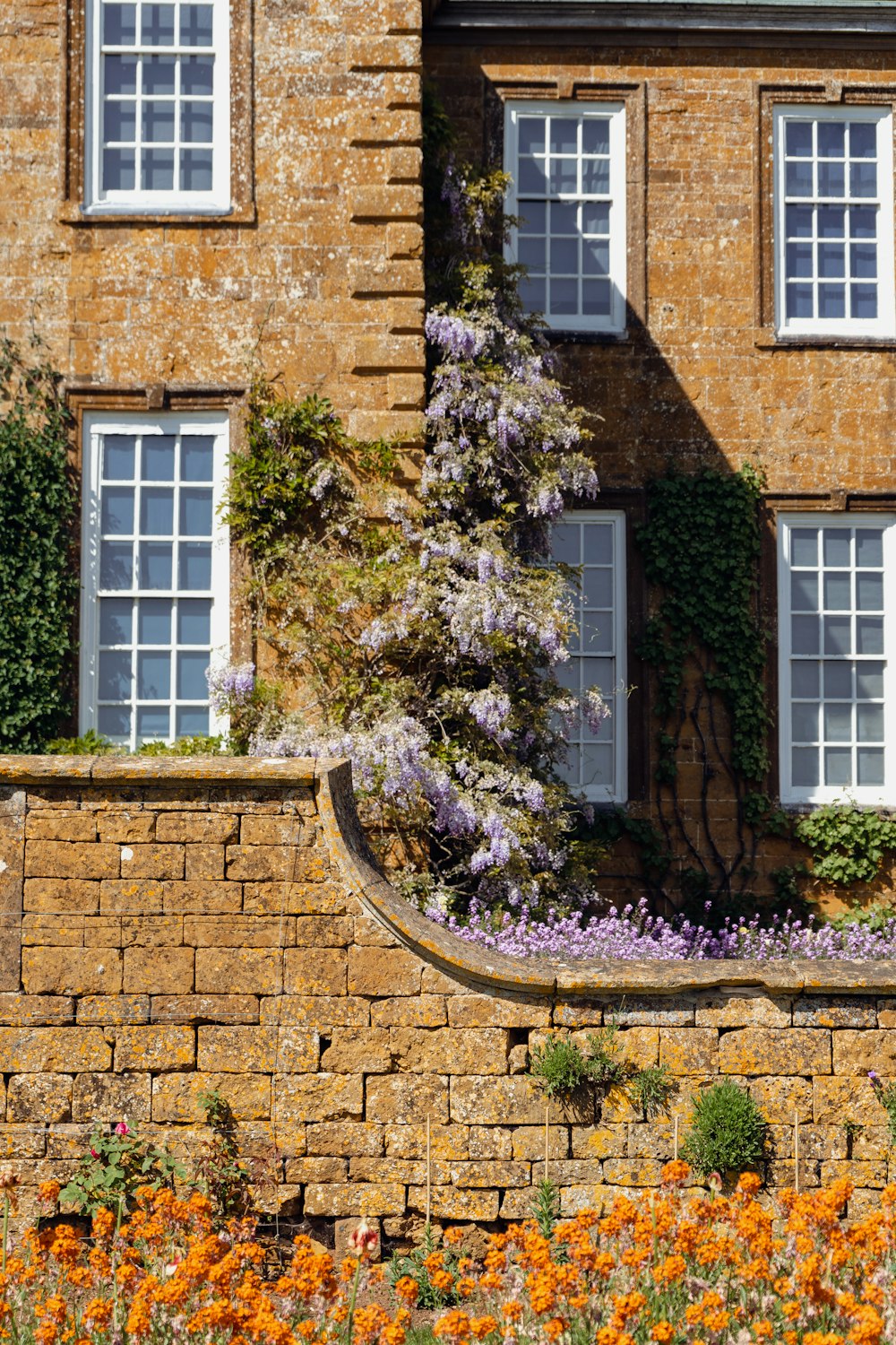 a brick building with flowers growing on the side of it