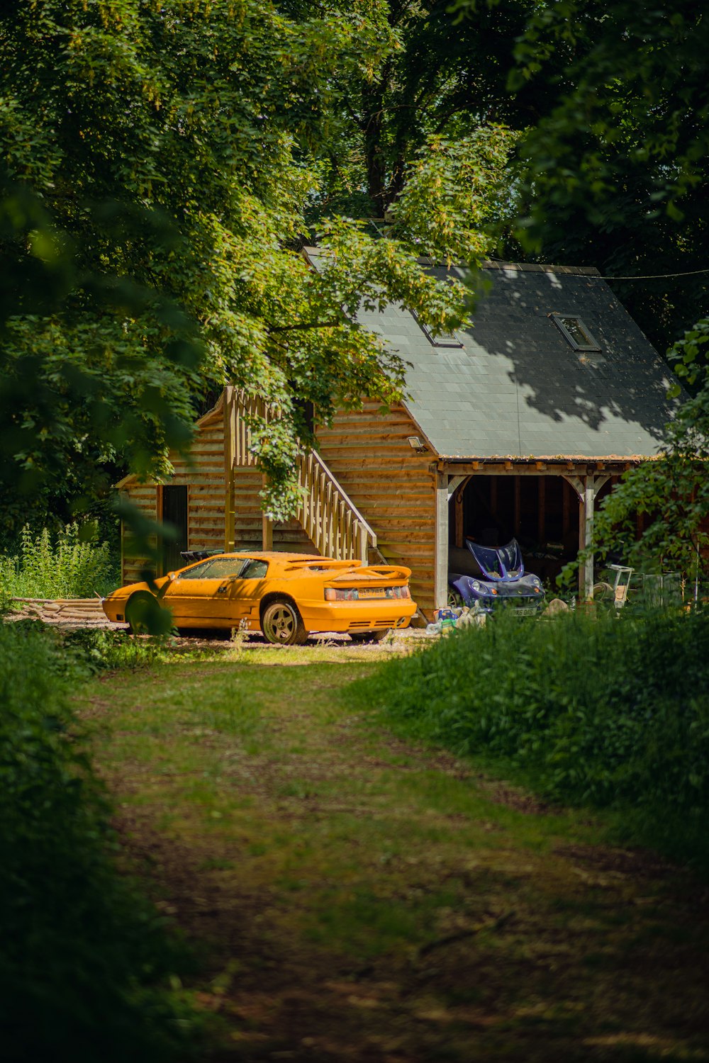 a yellow truck parked in front of a wooden cabin