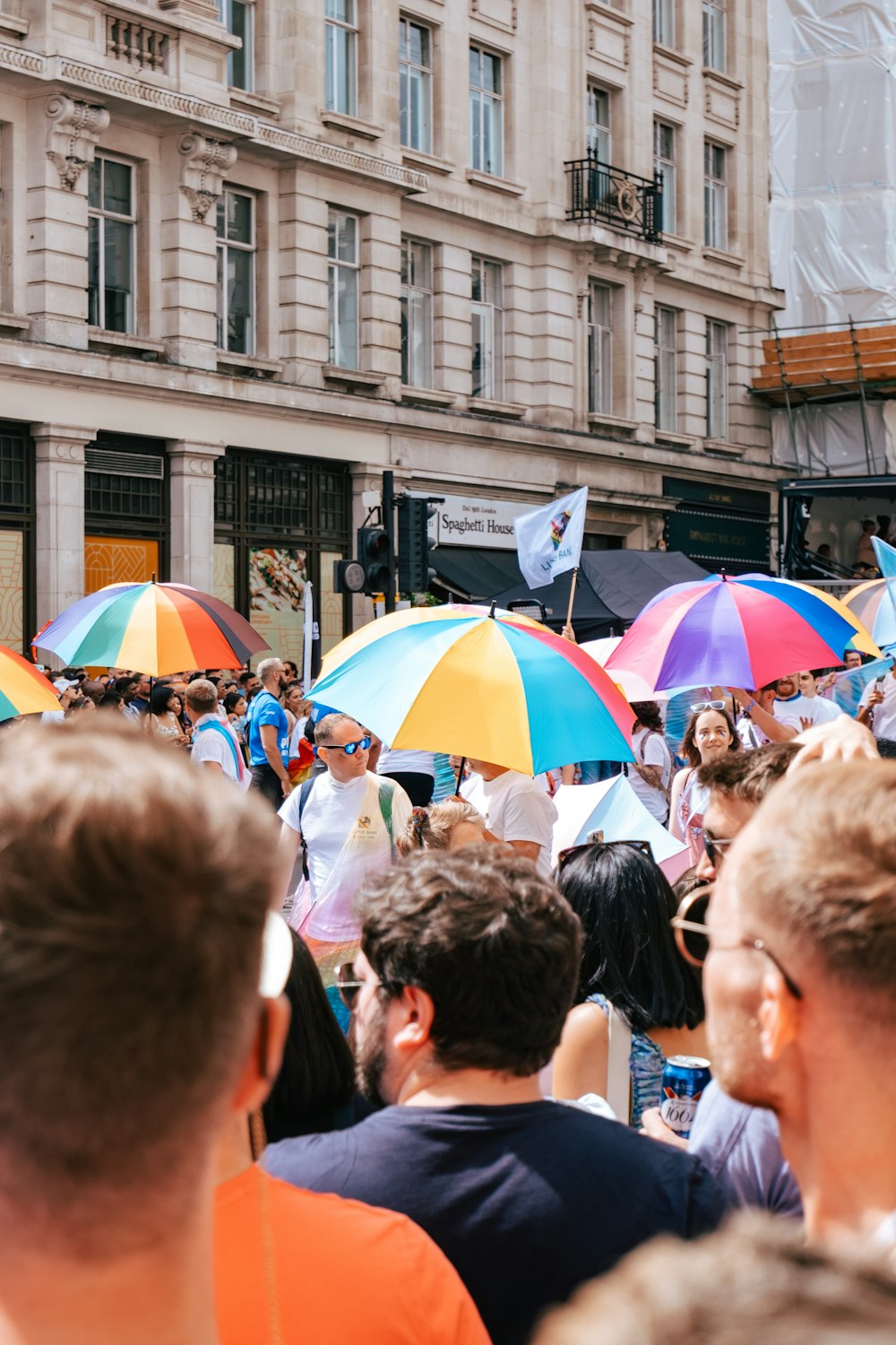 a crowd of people standing around each other holding umbrellas