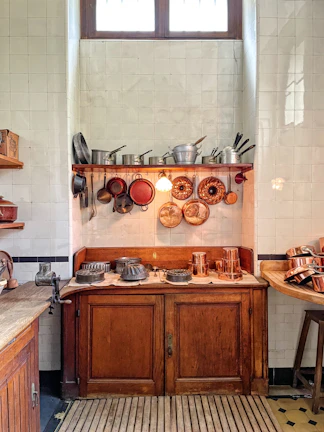 Rustic kitchen with open shelving displaying earthenware and copper pots.
