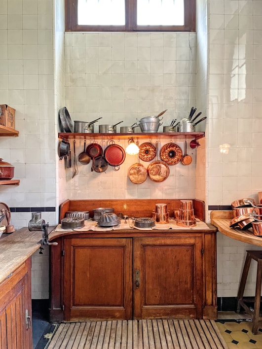 Cozy kitchen setup featuring colorful cookware and utensils on wooden shelves.