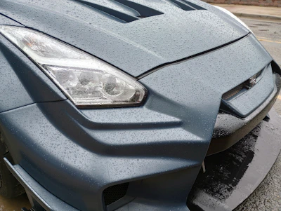 Dynamic angle of a sports car with water droplets beading off its surface.