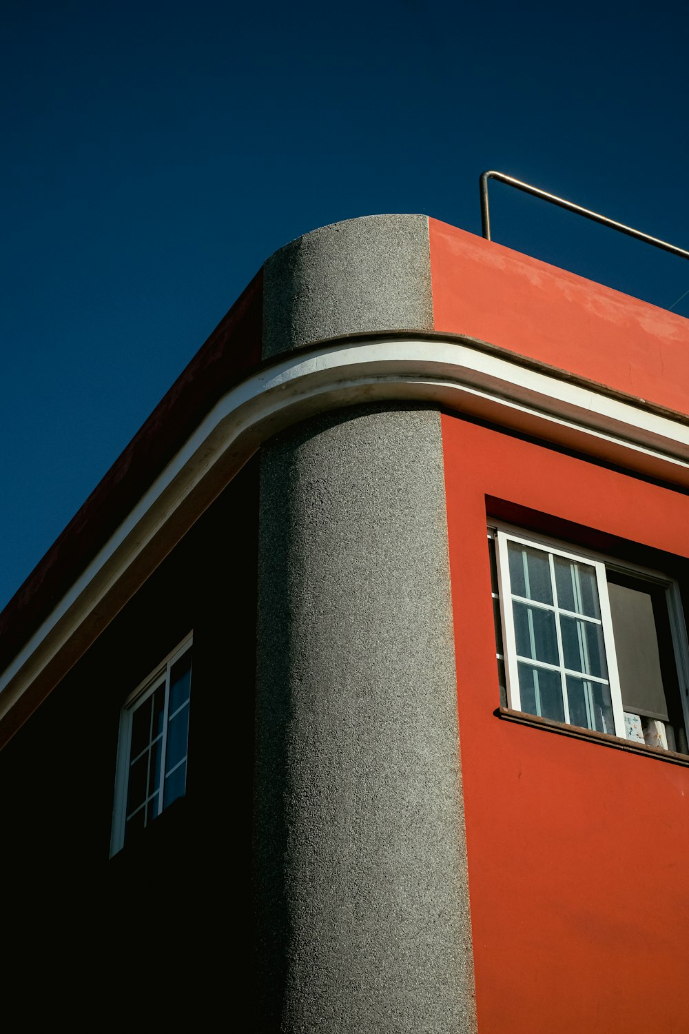 a red building with a window and a sky background