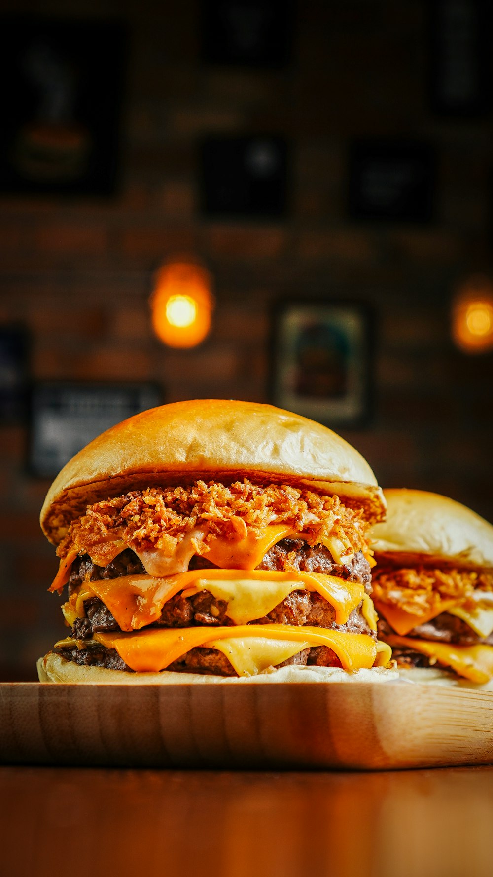 a large cheeseburger sitting on top of a wooden cutting board