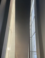 Sunlit penthouse interior showcasing flawless wall finishes and custom lighting.