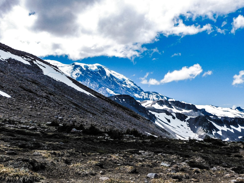 a snow covered mountain with a few clouds in the sky