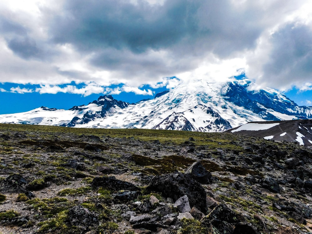 a mountain covered in snow under a cloudy sky