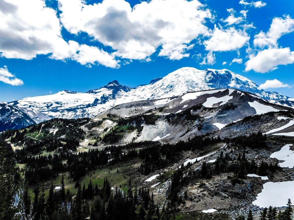 a snow covered mountain under a blue sky with clouds