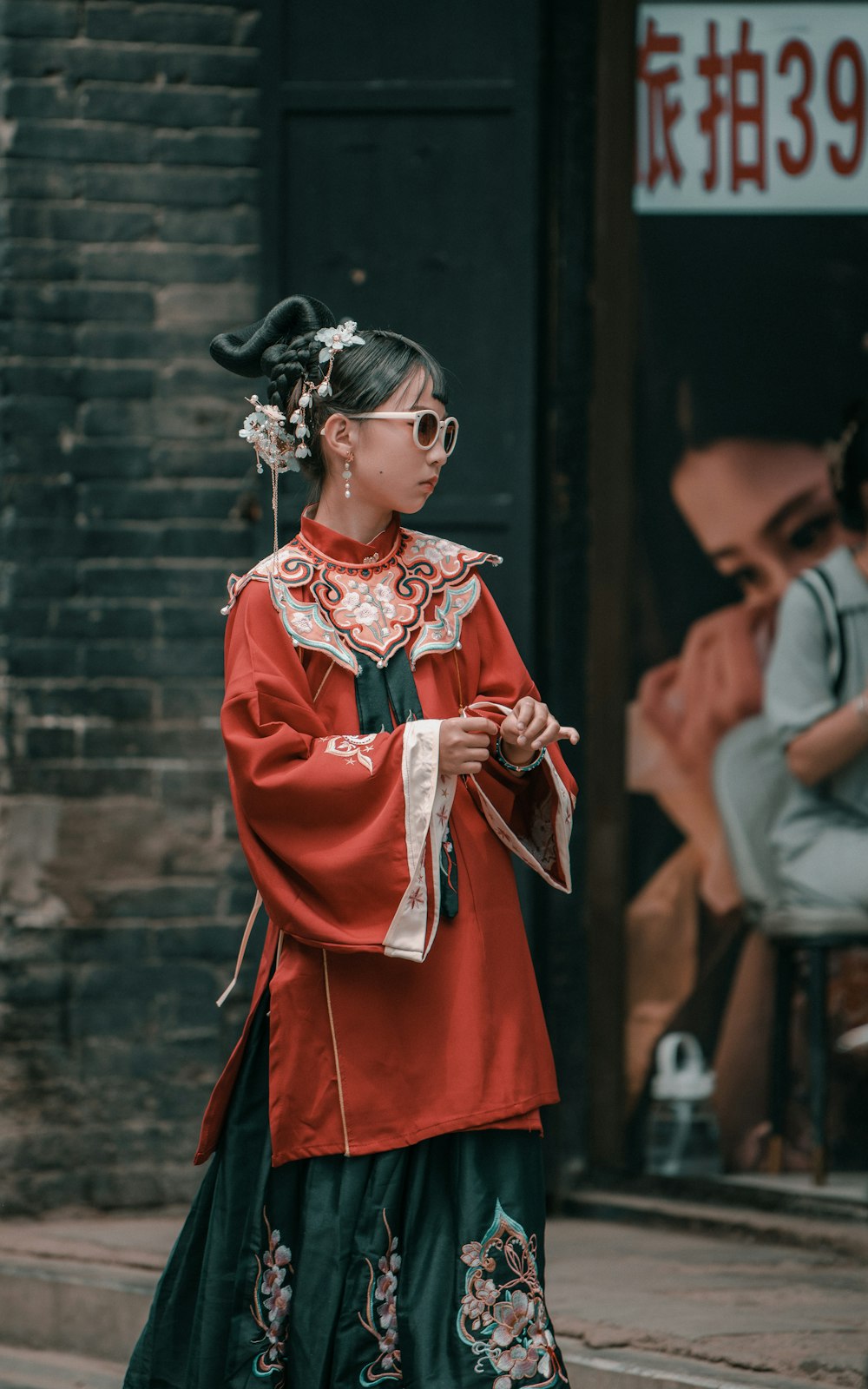 a woman walking down a street wearing a red and green outfit