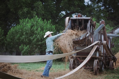 A ranch worker using a tablet to input feed data in an outdoor feedlot area.