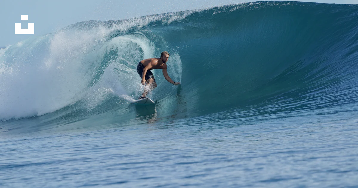 Man Riding Wave A man riding a wave on top of a surfboard photo – Free Mentawai islands ...