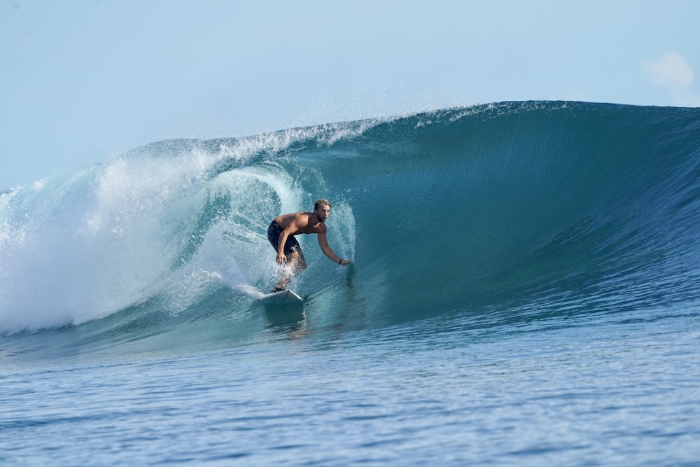 a man riding a wave on top of a surfboard