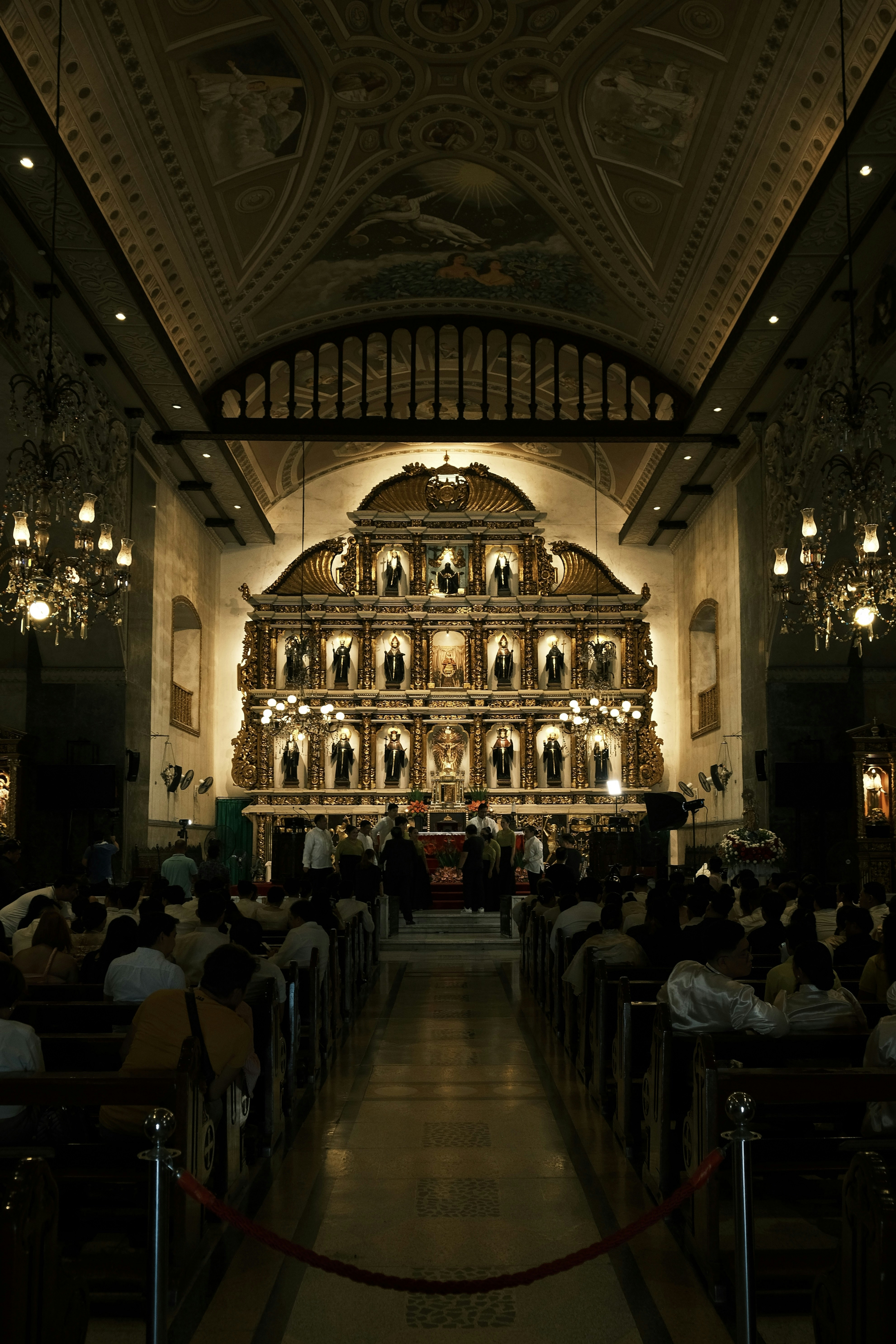 Church congregation in worship, dark atmospheric church with golden stage lights, silhouettes of worshippers