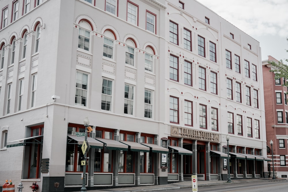 a tall white building sitting on the side of a street