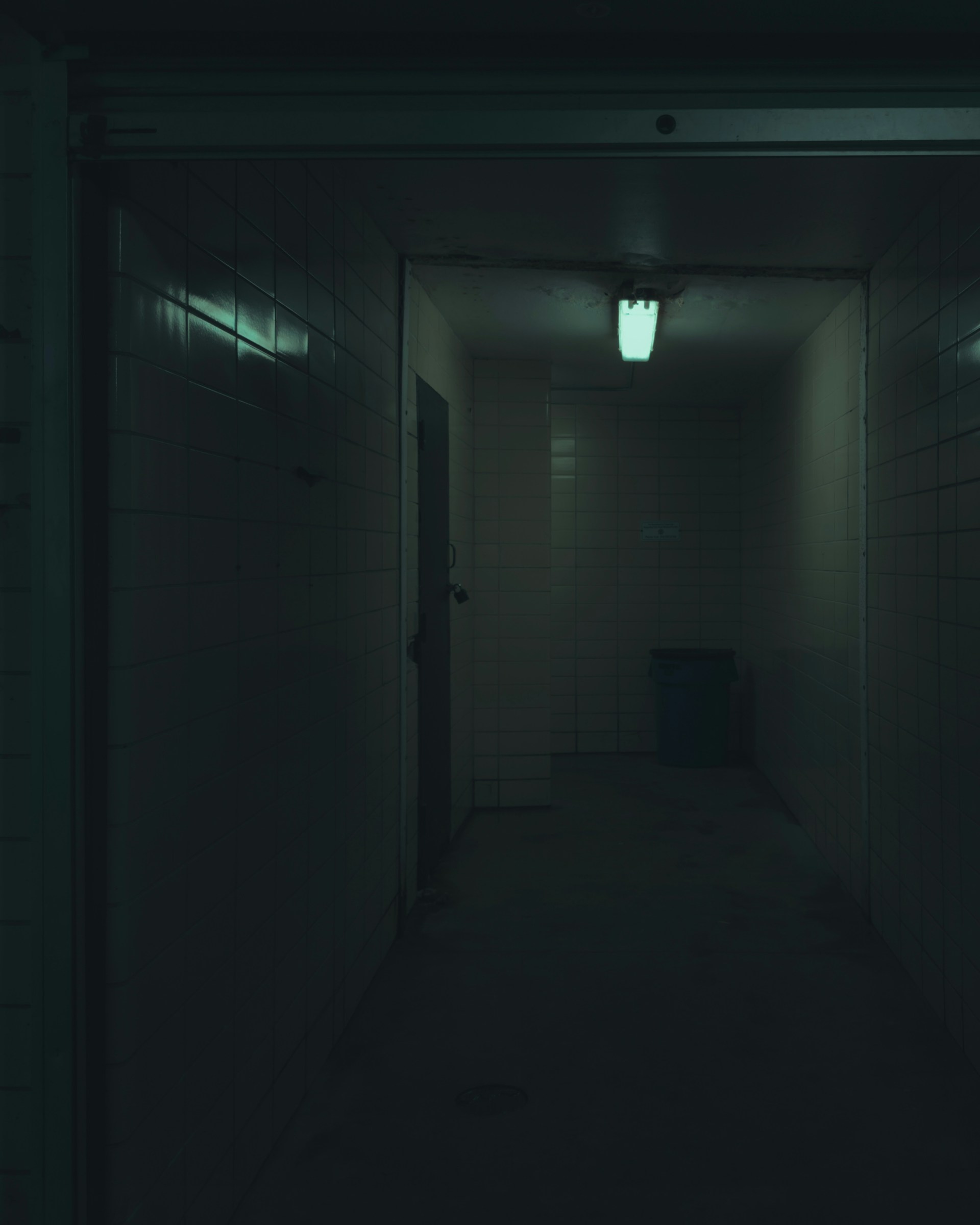 a dark hallway with a light on the ceiling