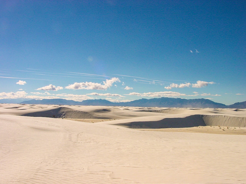 a person riding a snowboard on top of a sandy hill