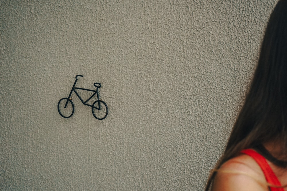 a woman standing in front of a wall with a bike drawn on it