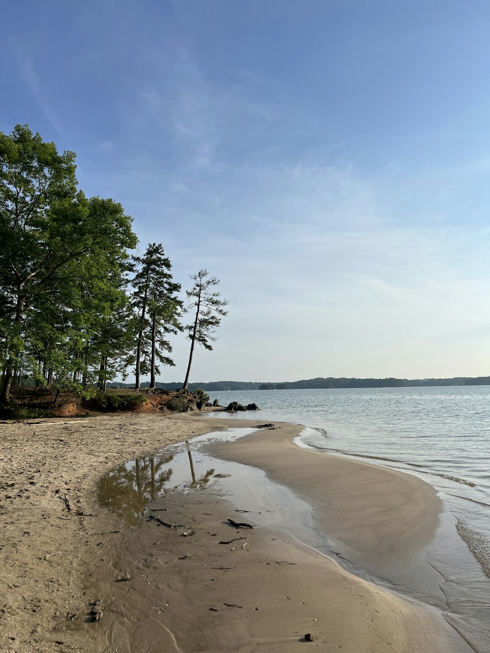 a sandy beach next to a body of water