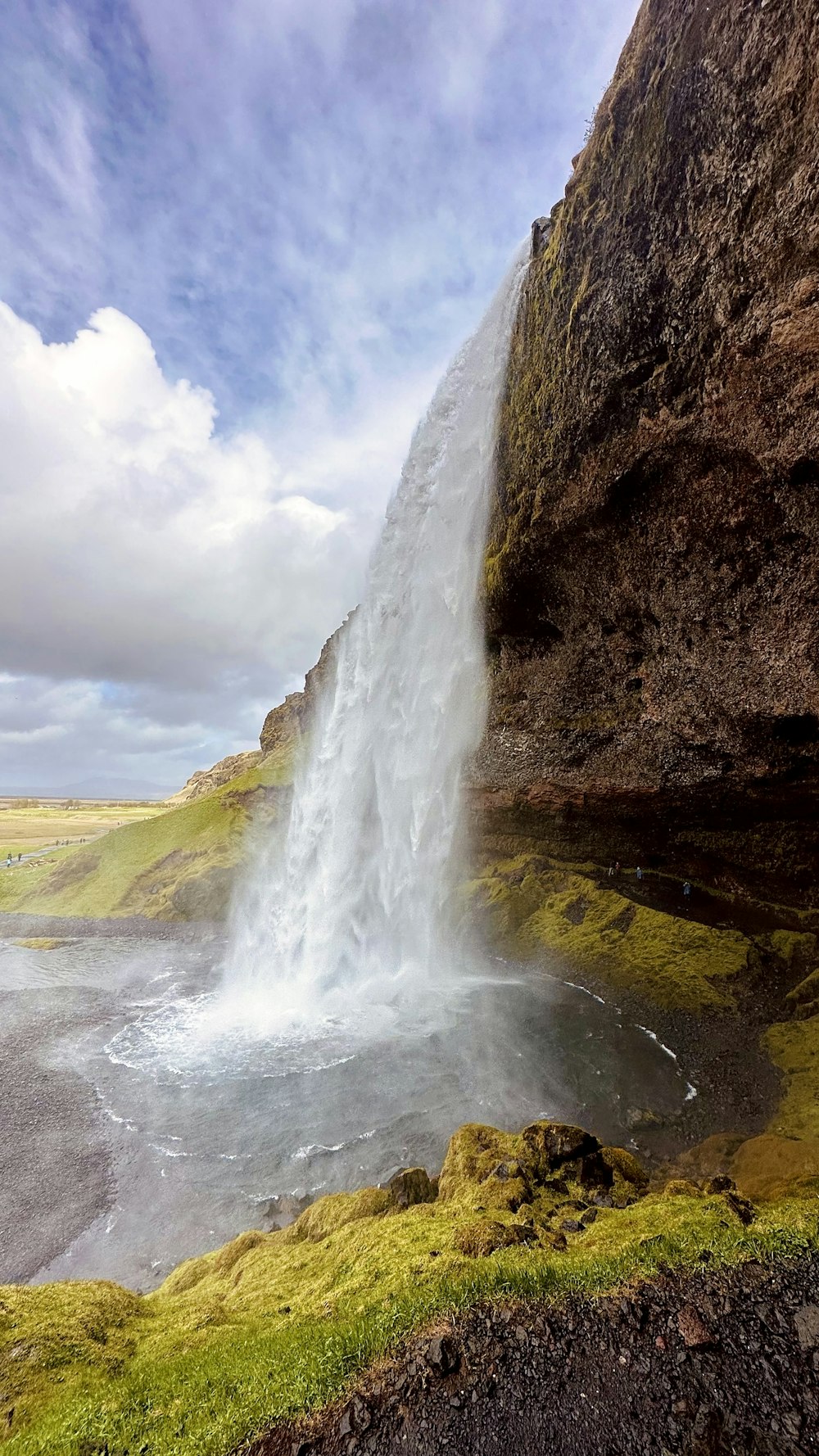 a large waterfall is coming out of the side of a mountain