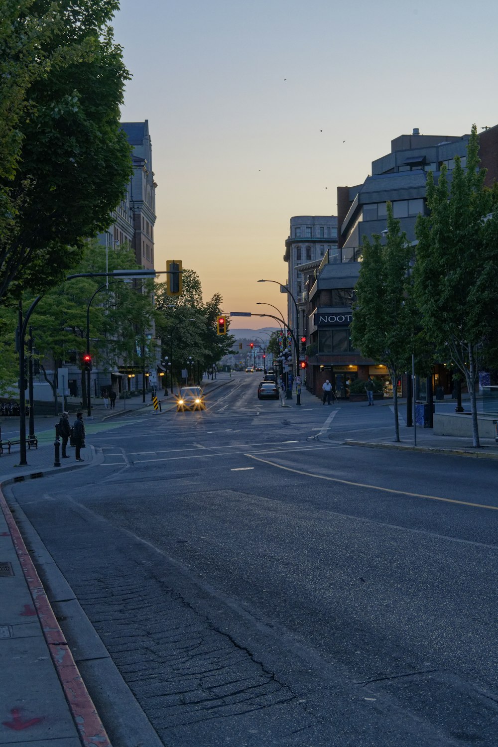 a city street with a few cars driving down it